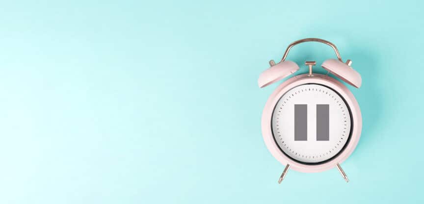 Rosa Wecker mit Pausensymbol auf einem mintgrünen Hintergrund