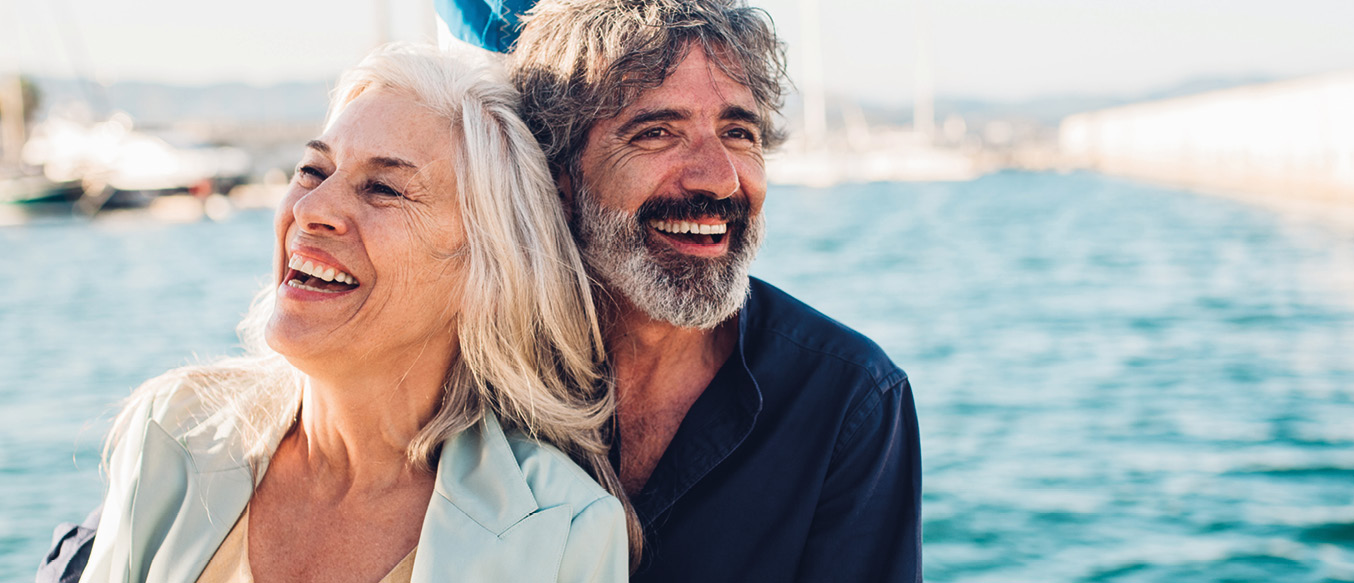 Ein lachendes älteres Paar auf einem Segelboot.