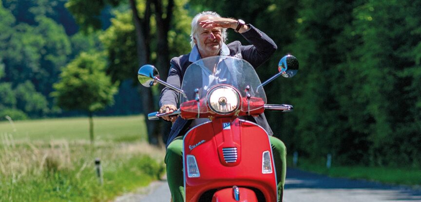 Der Reisebuchautor Michael Schottenberg fährt auf seiner roten Vespa.