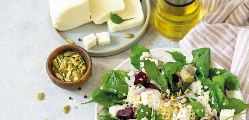 Mehrere Teller mit Frischkäse und Salatblättern.