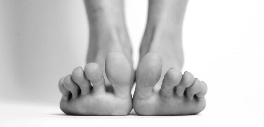 Zwei Füße in Schwarzweiß von vorne mit aufgestellten Zehen.