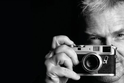 Manfred Baumann hält Analog-Kamera vors Gesicht.
