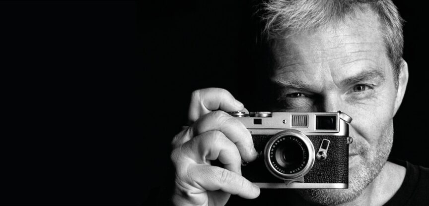 Manfred Baumann hält Analog-Kamera vors Gesicht.