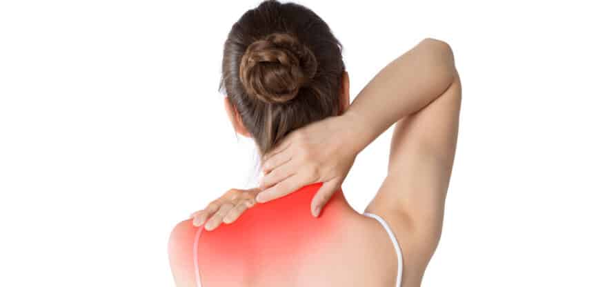 Frau hält sich mit beiden Händen den schmerzenden Nacken- und Schulterbereich, der rot markiert ist.