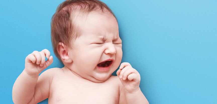 Weinendes Baby mit geschlossenen Augen vor blauem Hintergrund.