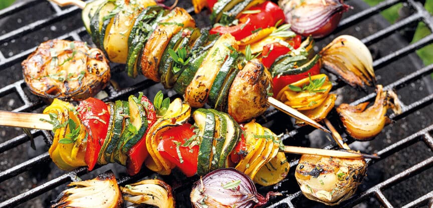 Bunte Gemüsespieße mit Paprika, Zucchini, Zwiebeln und Pilzen auf einem Grillrost – frisch, gesund und sommerlich angerichtet.