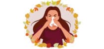 Illustration einer Frau, die sich in ein Taschentuch schnäuzt, umgeben von bunten Herbstblättern.