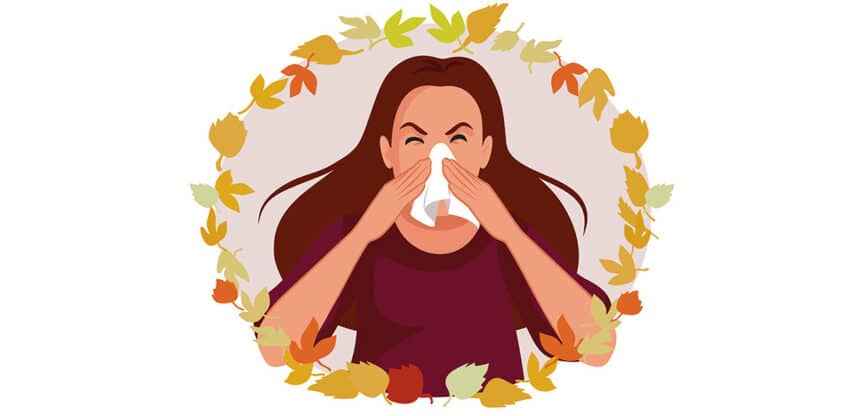 Illustration einer Frau, die sich in ein Taschentuch schnäuzt, umgeben von bunten Herbstblättern.