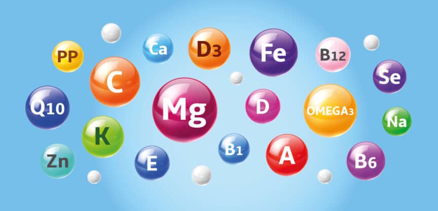 Bunte Kugeln mit den Kürzeln von Vitaminen und Mineralstoffen wie Magnesium, Eisen, Zink und Vitamin C – Symbolbild für Nährstoffe.